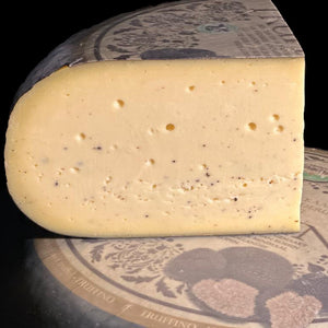 Trüffelgouda von Bert & Boni – Komposition aus einem Laib und einem angeschnittenen Stück, verfeinert mit italienischen Sommertrüffeln.