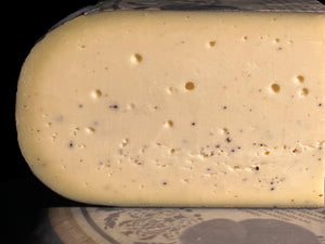 Trüffelgouda von Bert & Boni – leicht gezoomte Komposition aus einem Laib und einem angeschnittenen Stück, mit intensivem Trüffelaroma.