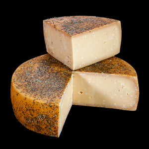 Ziegenheublumenkäse von Bert & Boni – Komposition aus einem Laib und einem angeschnittenen Stück, aromatischer Käse mit Heublumenaromen.